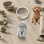 Dog-shaped keychain on a wooden surface with a small dog illustration.