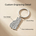 Silver keychain with cat design on a beige background, labeled for custom engraving detail.