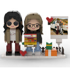 Two brick figures of people with accessories on a white background, with a smaller inset photo frame.