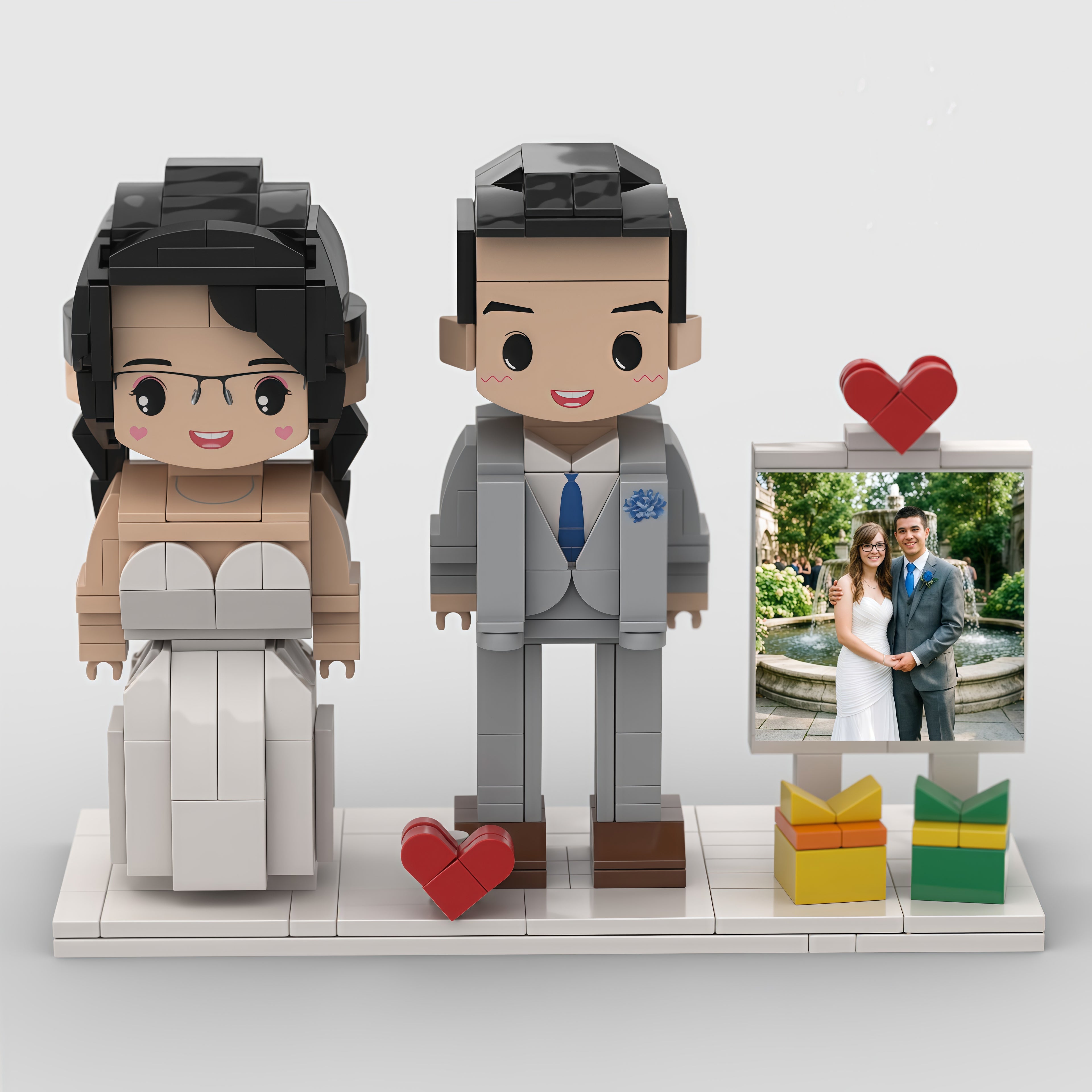 Brick-built figures of a bride and groom with a heart and photo frame on a white background
